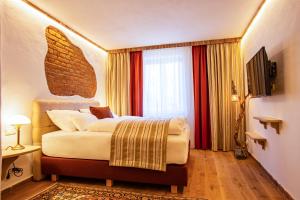 a bedroom with a large bed and a large window at Gasthof Lend-Platzl in Graz