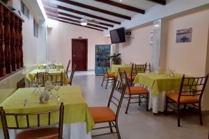Hotel Cayapas Esmeraldas في إسمرالداس: مطعم بالطاولات والكراسي مع غطاء الطاولة الأصفر