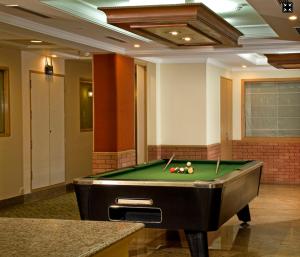 a pool table in a room with a pool table at Savoy Suites Noida in Noida