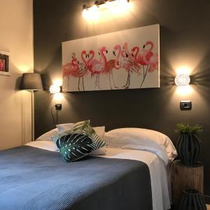 a bedroom with a bed with a painting of flamingos at Appartamenti Villa Tonni in Gabicce Mare