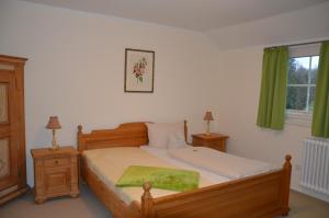 a bedroom with a bed with a green blanket on it at Hotel Holter Schloßkrug in Schloß Holte-Stukenbrock