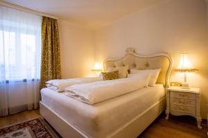 a bedroom with a large white bed with a window at Gasthof Lend-Platzl in Graz