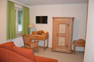 a living room with a desk and a table with a telephone at Hotel Holter Schloßkrug in Schloß Holte-Stukenbrock