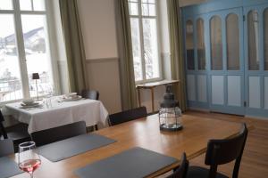 a dining room with a table and chairs and windows at Hotel Erica in Langenbruck +52 photos