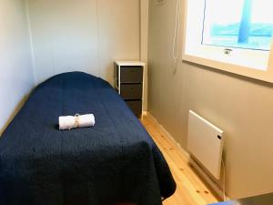 a room with a bed with a rolled up towel on it at Fishermans Dock Lofoten in Ballstad