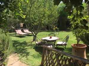 una mesa y sillas en un patio con un árbol en Dar Lorkam, en Skoura