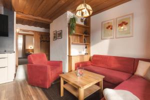 An der Via Claudia Augusta في فيس: غرفة معيشة مع أريكة حمراء وطاولة