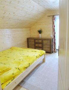 a bedroom with a yellow bed and a wooden wall at Cabana Larisei in Cluj-Napoca