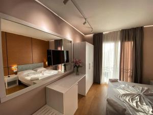 einen großen Spiegel in einem Hotelzimmer mit einem Bett in der Unterkunft Hotel Edart in Durrës