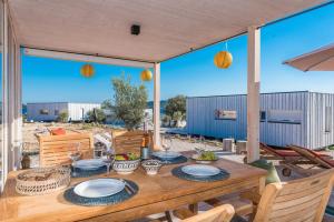 a wooden table with plates on it on a patio at BUQEZ Eco Resort - beachfront 20 & House 42 in Drage