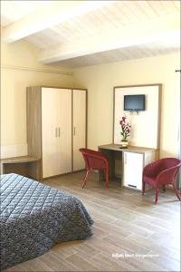 a bedroom with a bed and a table and chairs at Hotel Ristorante Cantina Langelina in Corinaldo