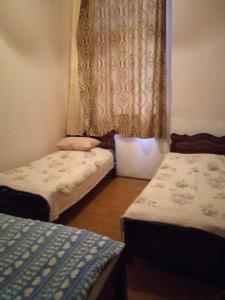um pequeno quarto com 2 camas e uma janela em Silence em Kutaisi