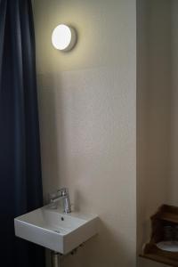 W łazience znajduje się umywalka i lustro. w obiekcie Hotel Erica w mieście Langenbruck