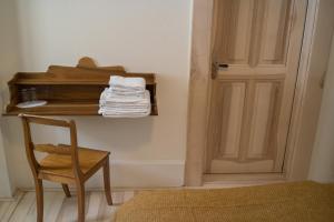 Pokój z krzesłem i półką z ręcznikami w obiekcie Hotel Erica w mieście Langenbruck