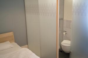 - une petite salle de bains avec un lit et des toilettes dans l'établissement Hotel Erica, à Langenbruck