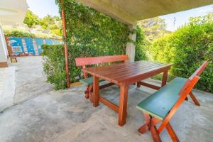 a wooden table and two chairs on a patio at Apartment Dumičić 1 in Rab +8 photos