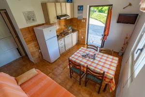 a small kitchen with a table and chairs and a refrigerator at Apartment Dumičić 1 in Rab