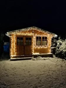 una casa cubierta de luces de Navidad en la nieve en Gästehaus Pöppl, en Unterwossen