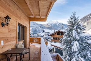 a balcony with a snow covered christmas tree on a cabin at Apart Alpenland in Mayrhofen