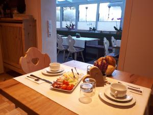 a table with a tray of fruit on top of it at Gästehaus Pöppl in Unterwössen