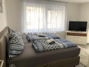 uma cama com almofadas e uma televisão num quarto em Özkurt-1 em Friedrichshafen
