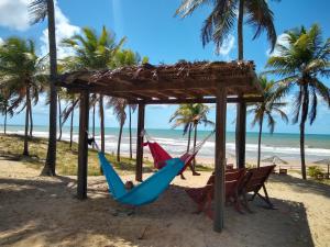 two hammocks on a beach with palm trees at Hotel Coco Beach in Conde
