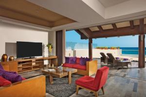 a living room filled with furniture and a flat screen tv at Secrets Vallarta Bay Resort & SPA - Adults Only in Puerto Vallarta