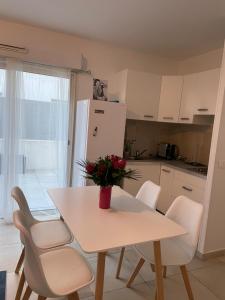 eine Küche mit Tisch und Stühlen und einem Kühlschrank in der Unterkunft Appartement la plage de la pointe rouge in Marseille + 8 Fotos