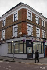 a man walking down a street in front of a building at Burren London Hotel in London