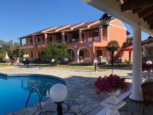 a resort with a swimming pool and a building at Regina Nina in Vasilátika