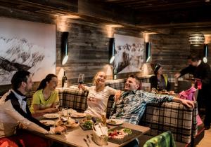 um grupo de pessoas sentadas em torno de uma mesa em um restaurante em Mountain alpine em Kappl