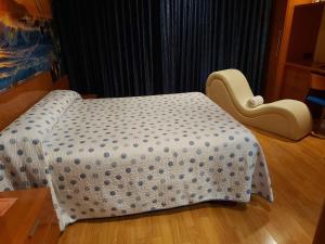 1 cama y 1 silla en una habitación en Motel Acropolis, en Camponaraya