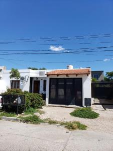 a small white house with a garage at Dpto cercano al centro con WIFI in San Luis