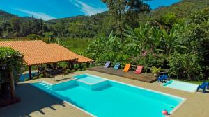 a pool with a gazebo and a house at Pousada Kafundó - Inhotim in Brumadinho