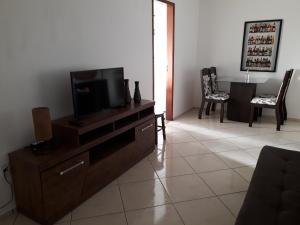 una sala de estar con TV de pantalla plana en una cómoda en Apartamento Orquídea en Campos dos Goytacazes