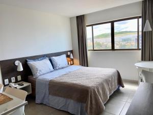 1 dormitorio con cama y ventana grande en Hotel Ritz Condômino Adler Ricardo en Maceió