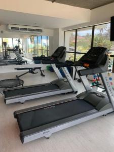 a gym with several treadmills and elliptical machines at Hotel Ritz Condômino Adler Ricardo in Maceió