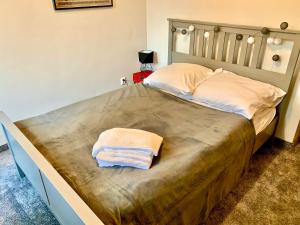 a large bed with a wooden headboard and two towels on it at APARTAMENT GIMNAZJALNA 8a (Maria Mąka) in Zakopane