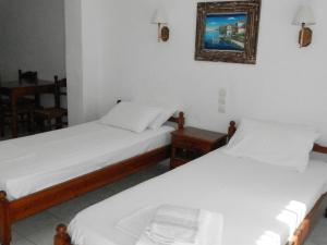 two beds in a room with a picture on the wall at Aeolos Hotel Apartments in Gythio