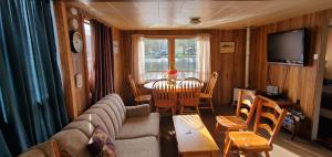 ein Wohnzimmer mit einem Sofa, einem Tisch und einem TV in der Unterkunft Trent River Cottages in Hastings
