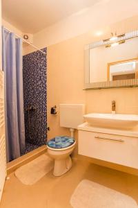 e bagno con servizi igienici, lavandino e doccia. di Apartments Zonta 800 m From Beach a Rovigno (Rovinj)