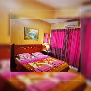 a bedroom with a large bed with pink curtains at Regis Hotel in Beirut