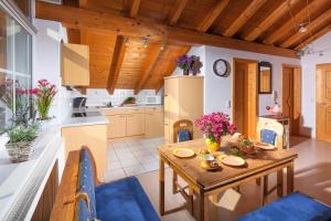 eine Küche und ein Esszimmer mit einem Holztisch und blauen Stühlen in der Unterkunft Siglbauernhof in Laufen