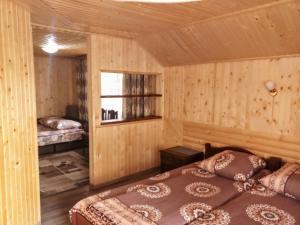 a room with two beds in a wooden room at Гостинний комплекс "У Валентини" in Yablunytsya