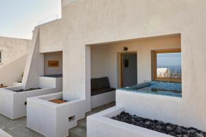 a house with a pool in the middle of a building at Alyvia Suites in Oia