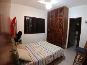 a bedroom with a bed and a closet at Meu Cantinho in Itanhaém
