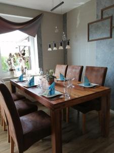 a wooden table with chairs and a dining room at Ferienwohnung Zeit für uns in Berumbur