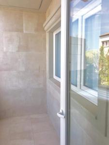 a bathroom with a glass door and a window at Apart Amabile Sul Mare in Villa Gesell