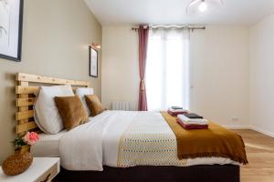 StayLib - Lovely 2 rooms porte de Montmartre في سانت وان: غرفة نوم بسرير كبير ونافذة