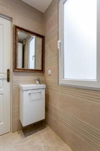 La salle de bains est pourvue d'un lavabo et d'un miroir. dans l'établissement StayLib - Lovely 2 rooms porte de Montmartre, à Saint-Ouen